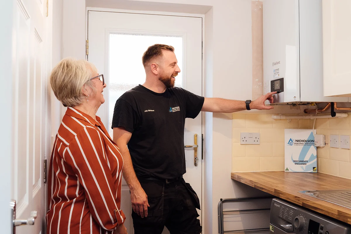 Nicholson Heating Services team with customer 
